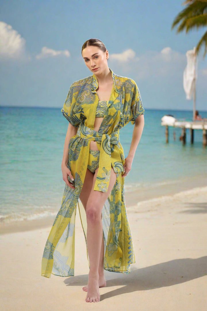Monaco Kimono in yellow and blue print, sheer luxury resortwear cover-up on beach.