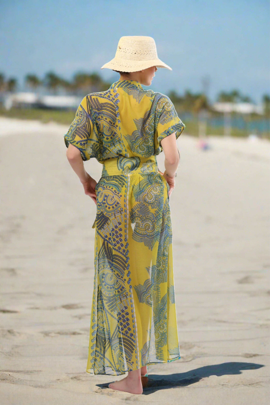 Monaco Kimono in sheer yellow and blue print on beach, luxury resortwear.