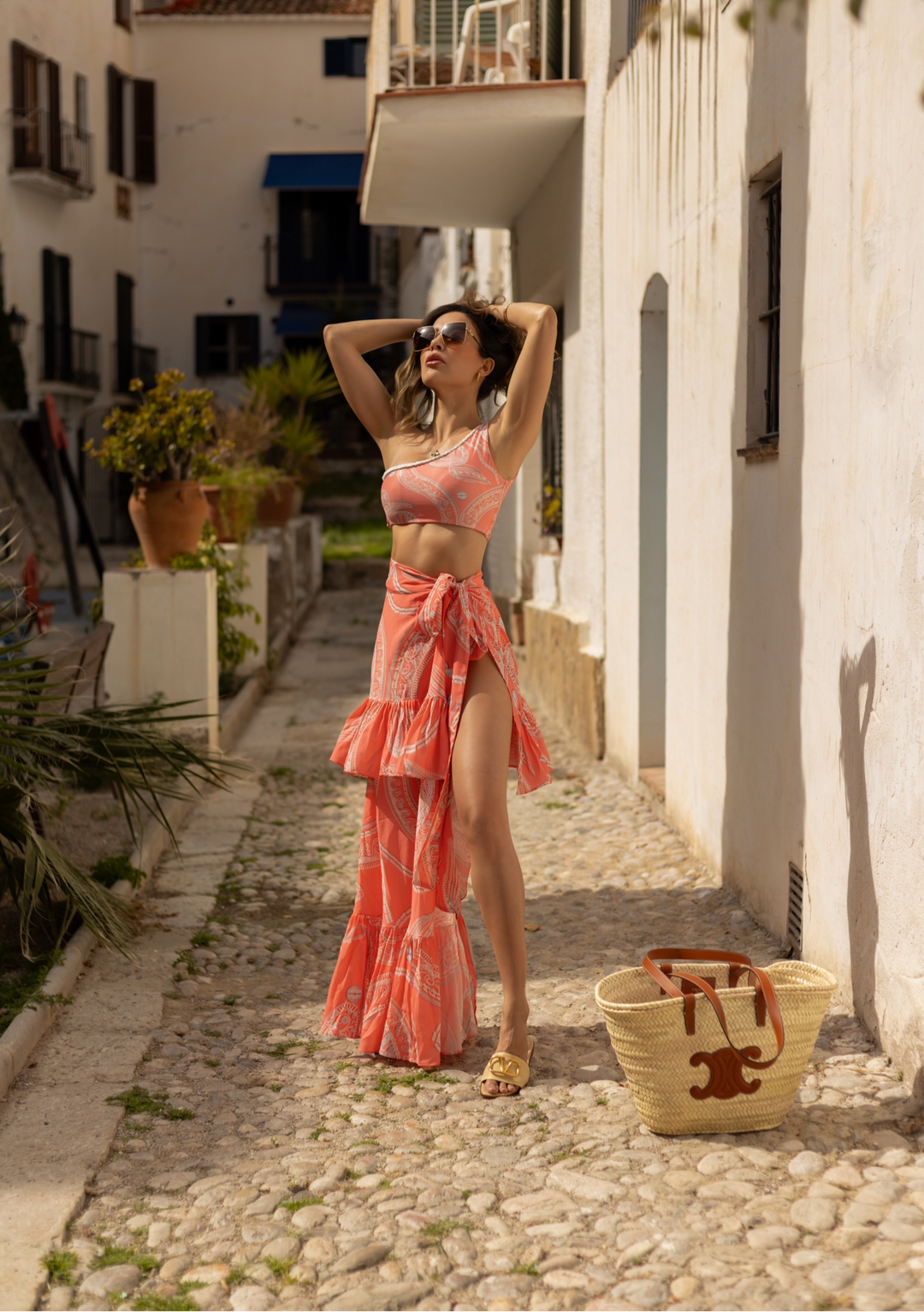 French Riviera Two-Piece Swimsuit in coral print, featuring one-shoulder top and high-waisted bottoms, perfect for luxury resort vacations.
