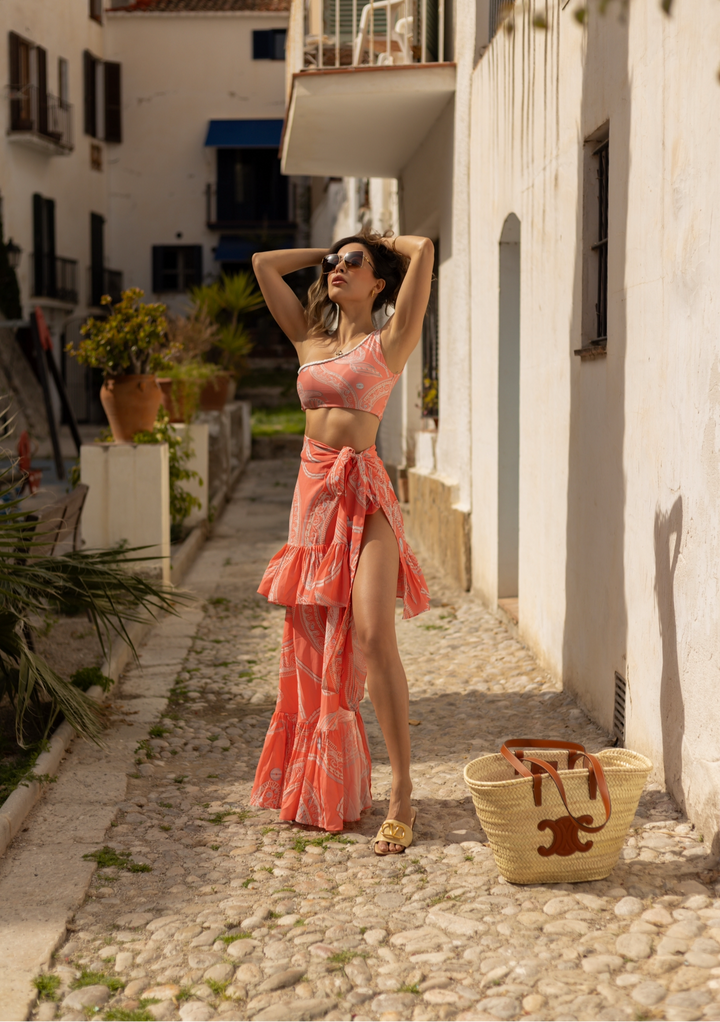 French Riviera Two-Piece Swimsuit in coral print, featuring one-shoulder top and high-waisted bottoms, perfect for luxury resort vacations.