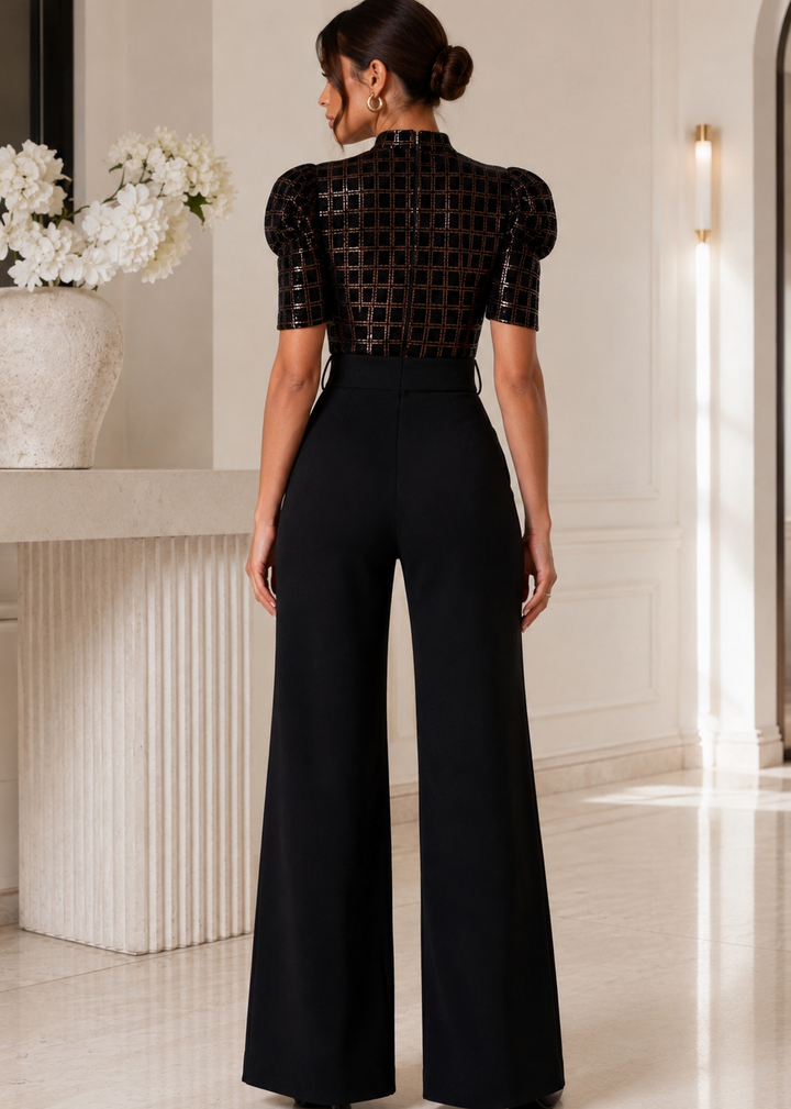 Back view of the Andrea black sequin jumpsuit showcasing the sparkling sequin bodice, structured high-waisted fit, and elegant wide-leg silhouette in a refined luxury setting.