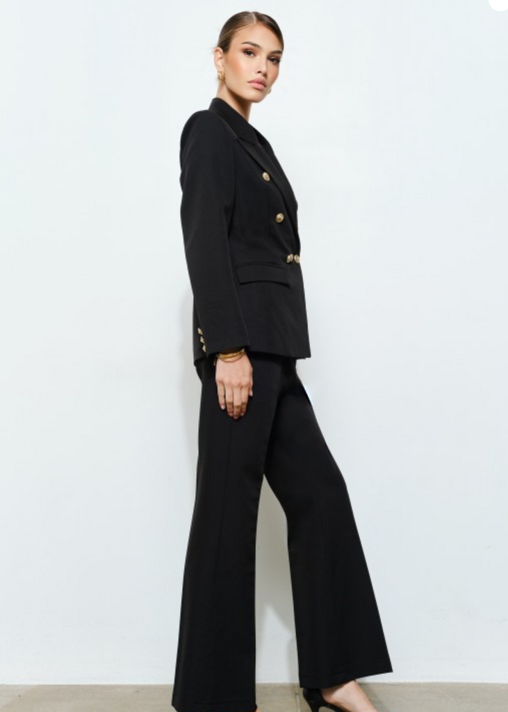 Woman wearing a black double-breasted blazer with gold buttons and tailored trousers – Elegance By Marislay