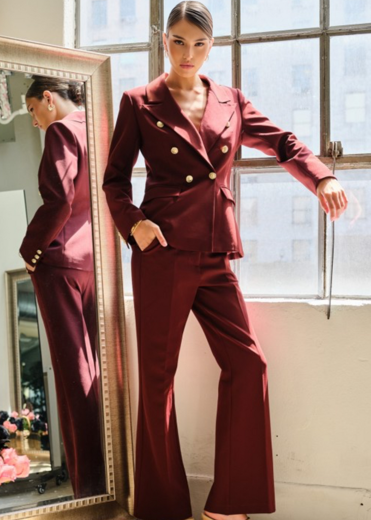  Confident woman in burgundy tailored pantsuit with gold button accents, perfect for meetings and networking