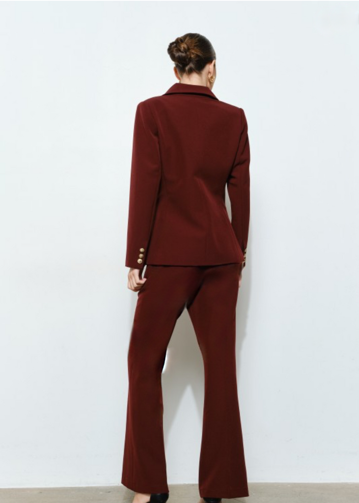 Woman wearing a burgundy double-breasted suit set with gold buttons, elegant business attire for work and conferences