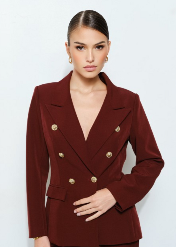 Elegant burgundy two-piece suit with fitted blazer and wide-leg pants, luxury office attire.