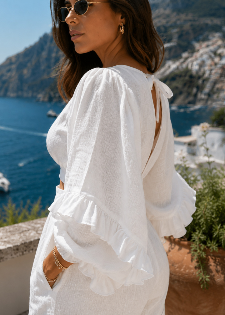 Close-up of The Capri Luxe White Linen Set showcasing premium linen fabric, elegant ruffle sleeves and refined craftsmanship.