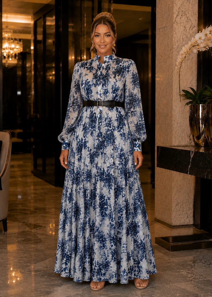 Woman wearing JOUI Floral Long Sleeve Maxi Dress with elegant floral print and button front in a luxury hotel lobby.