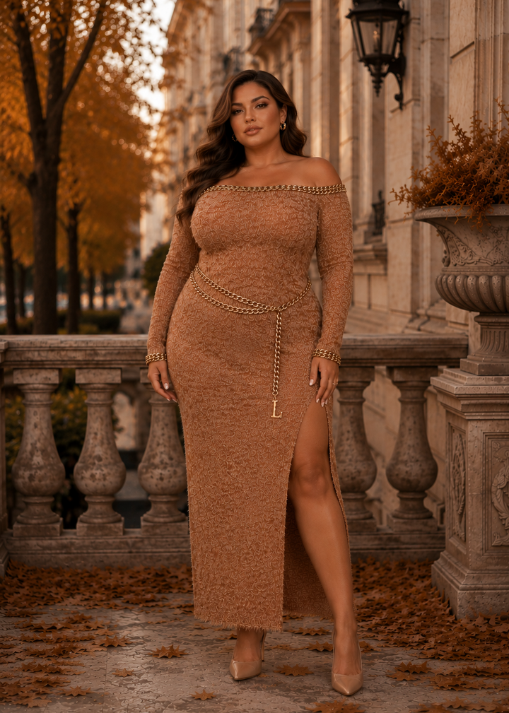 Plus size model wearing the Lisandra camel off shoulder knit maxi dress with gold chain belt in an elegant autumn luxury setting.