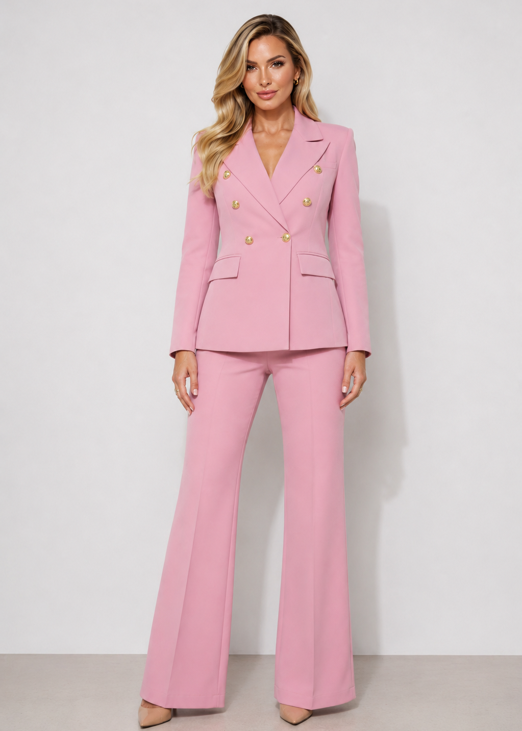 Pink three-piece tailored pantsuit with gold buttons for women featuring a structured blazer, matching vest, and wide-leg trousers.
