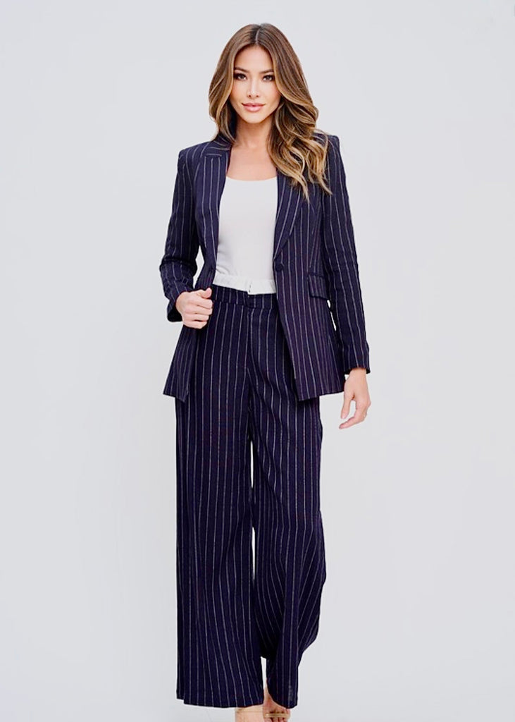 Elegant professional woman in a navy pinstripe suit with blazer, tailored trousers, and white blouse – stylish business outfit for corporate women