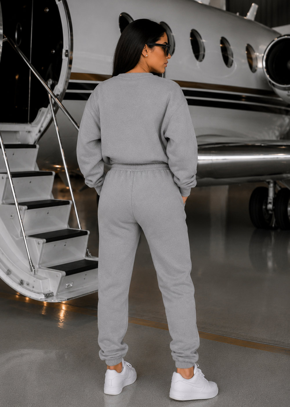 Back view of the SNUG SQUAD Grey 3-Piece Travel Lounge Set in premium grey fleece featuring a clean minimalist design inside a luxury private jet hangar.